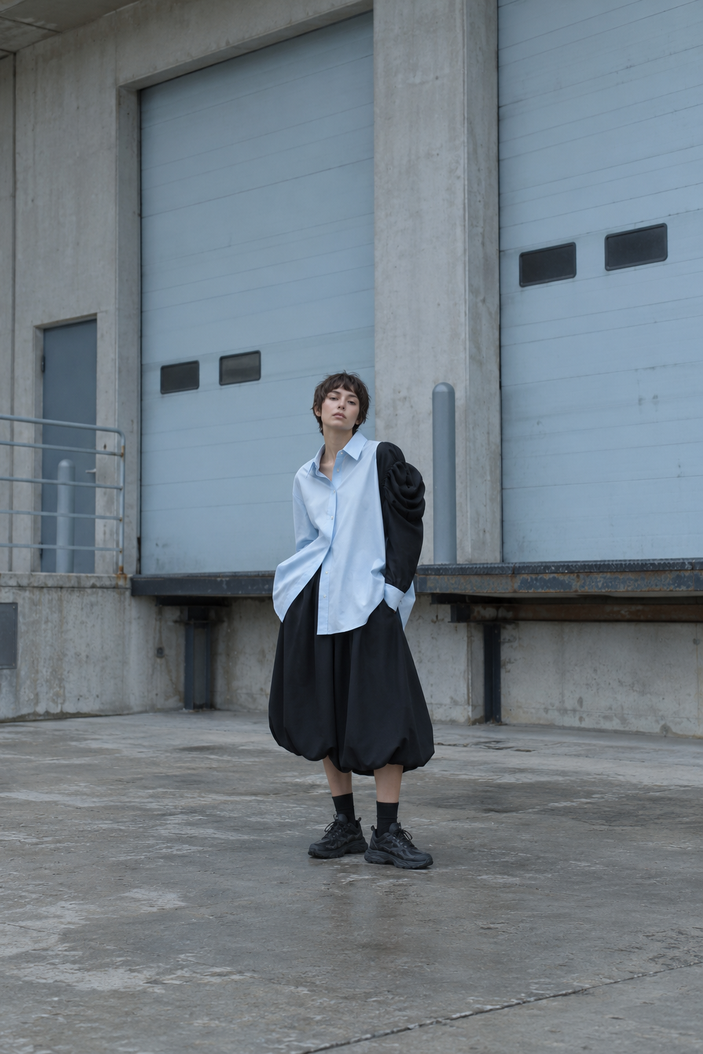 アイスブルーのシャツと黒いバルーンスカートを着た若いモデル